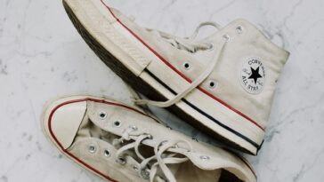 A pair of vintage Converse sneakers on a marble surface, showcasing classic style.