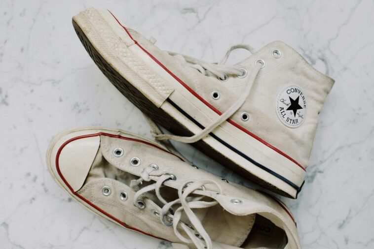 A pair of vintage Converse sneakers on a marble surface, showcasing classic style.