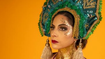 Close-up portrait of a woman wearing a traditional kokoshnik headdress on a vibrant yellow background.