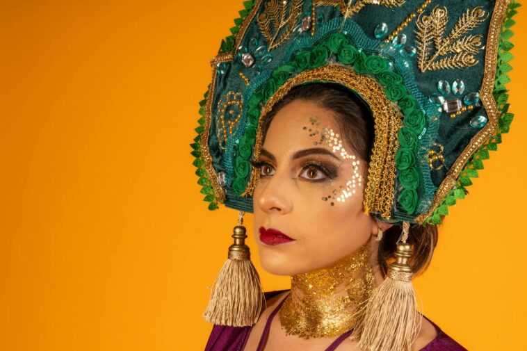 Close-up portrait of a woman wearing a traditional kokoshnik headdress on a vibrant yellow background.
