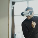 Adult male experiencing virtual reality with a headset inside a modern room.