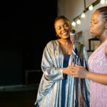 Two women performing together on stage, sharing a passion for music.