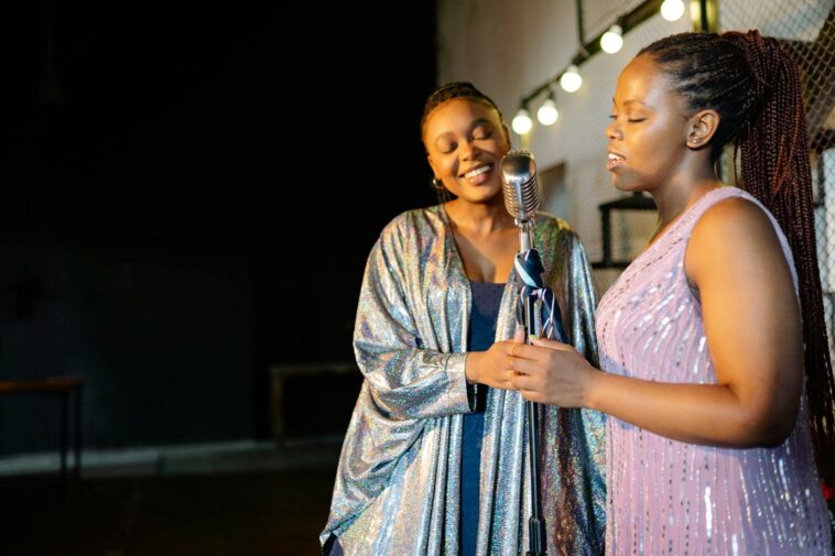 Two women performing together on stage, sharing a passion for music.
