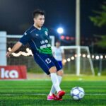 Soccer player in action on a lit field, capturing the dynamic energy of the game at night in Hà Nội.