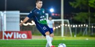 Soccer player in action on a lit field, capturing the dynamic energy of the game at night in Hà Nội.
