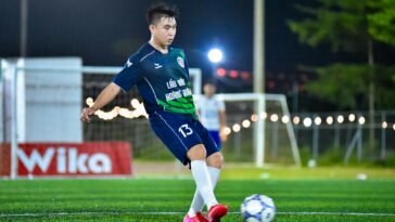 Soccer player in action on a lit field, capturing the dynamic energy of the game at night in Hà Nội.