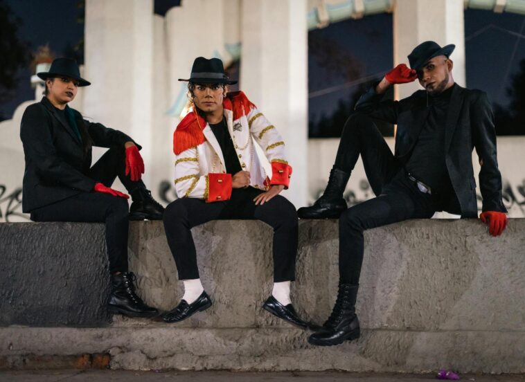 Three people in Michael Jackson-inspired outfits pose confidently at night in Mexico City.